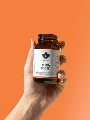 Nainen pitelee kädessään Puhdistamon Energy Boost -purkkia